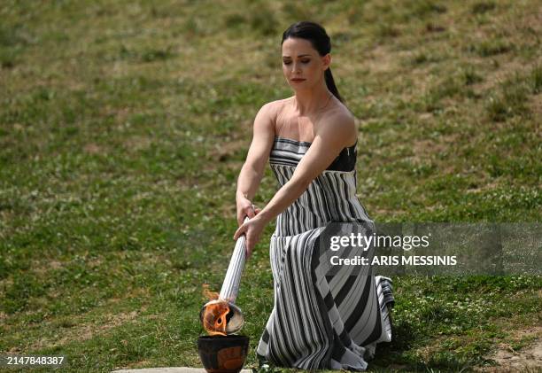 Greek actress Mary Mina, playing the role of the High Priestess, lights the torch during the flame lighting ceremony for the Paris 2024 Olympics...