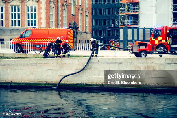 Firefighter prepare to pump water from a river to tackle a fire at Borsen, Denmark's old stock exchange building, in Copenhagen, Denmark, on Tuesday,...