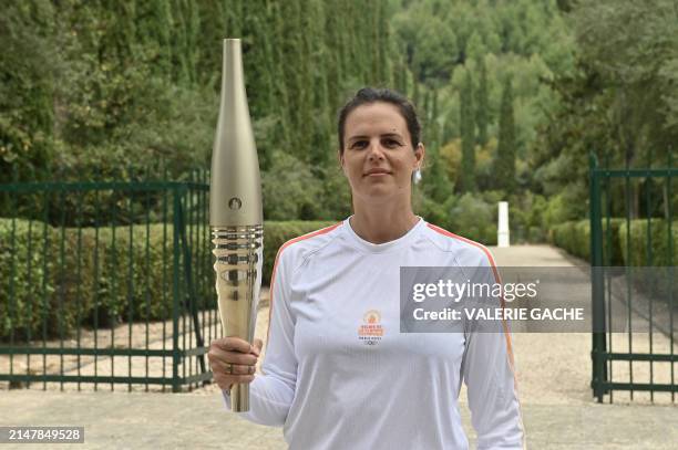 Second torch bearer, French Olympic swimmer, Laure Manaudou, poses with the Olympic torch during the flame lighting ceremony for the Paris 2024...