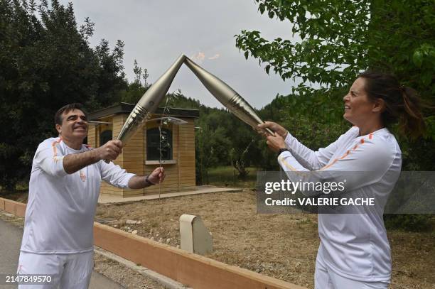 Second torch bearer, French Olympic swimmer, Laure Manaudou , lights the torch held by European Commission vice-president "Protecting our European...