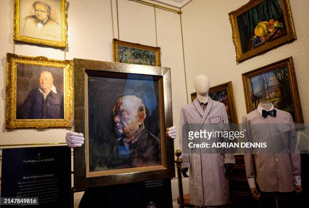 Matthew Floris, a Sotheby's employee poses with a portrait, a surviving study of Winston Churchill in the bedroom where Churchill was born at...
