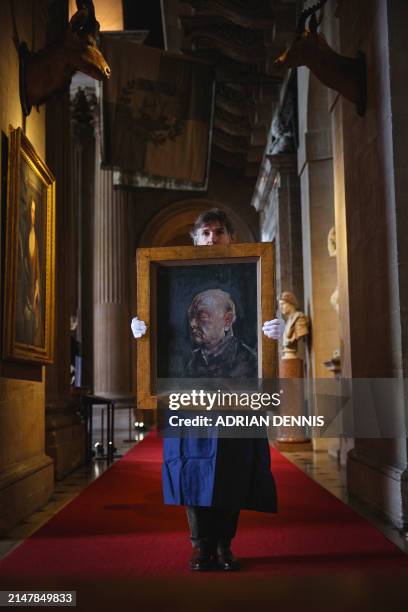 Matthew Floris, a Sotheby's employee poses with a portrait, a surviving study of Winston Churchill, at Blenheim Palace, north of Oxford, home to the...