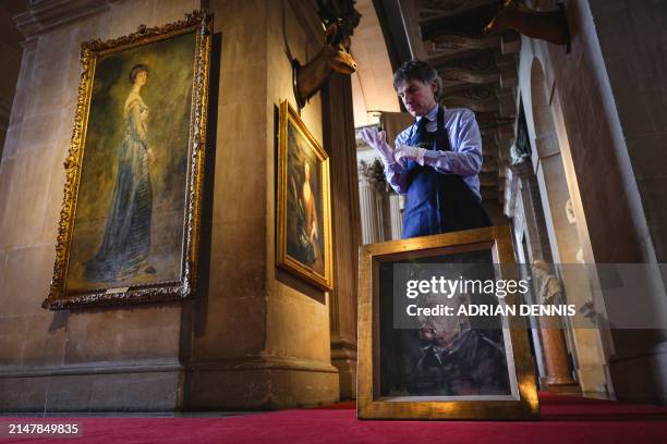 Matthew Floris, a Sotheby's employee poses with a portrait, a surviving study of Winston Churchill, at Blenheim Palace, north of Oxford, home to the...