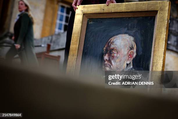 Matthew Floris, a Sotheby's employee poses with a portrait, a surviving study of Winston Churchill, at Blenheim Palace, north of Oxford, home to the...