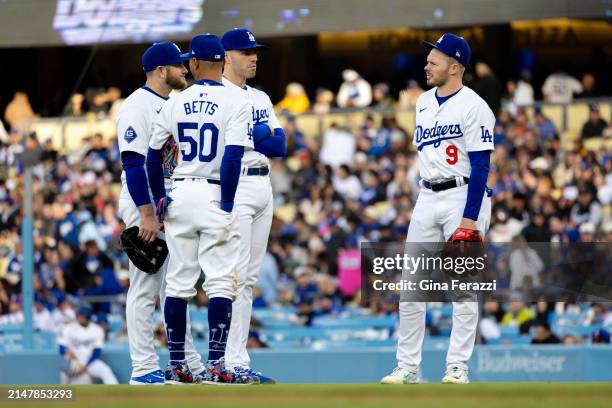 Dodgers infielders Gavin Lux , Mookie Bets , Max Muncy and Freddie Freeman chat while a new relief pitcher warms up during the game against the San...