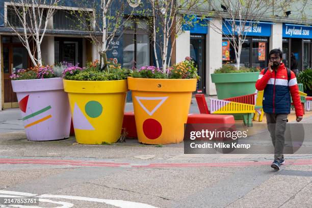 People interacting with large scale flower colourful pots on Southwark Street on 10th April 2024 in London, United Kingdom.