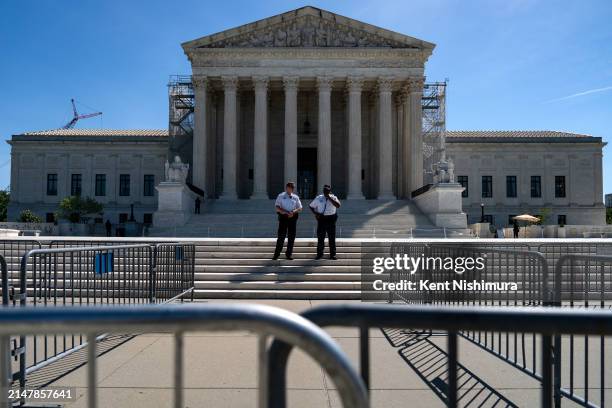 Supreme Court Police officers stand on the steps of the nation's high court as supporters of January 6 defendants including Micki Witthoeft, the...