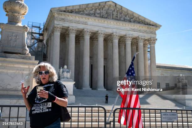 Micki Witthoeft, the mother of Ashli Babbitt, who was killed on January 6 smokes a cirgarette as she and others gather outside of the Supreme Court...