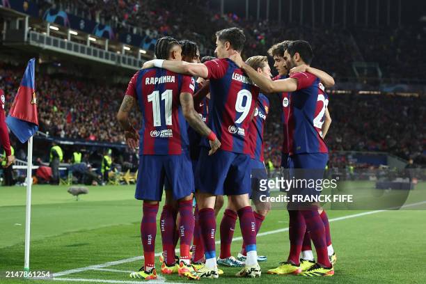 Barcelona's Brazilian forward Raphinha celebrates with teammates after scoring his team's first goal during the UEFA Champions League quarter-final...