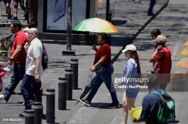 Person is covering themselves from the sunlight with an umbrella on the streets of the Zócalo in Mexico City. The National Water Commission reports...