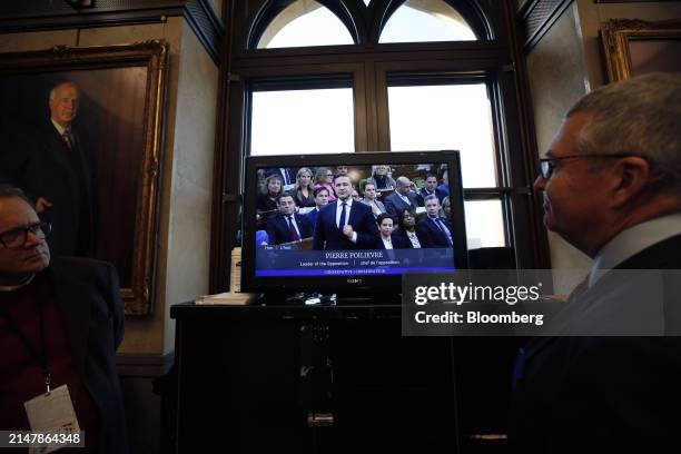 Members of the media watch Pierre Poilievre, leader of Canada's Conservative Party, on Parliament Live TV in the House of Commons foyer in Ottawa,...