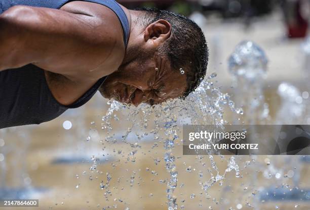 Man cools off at a water fountain in the Monumento a la Revolucion square during a heat wave that hits Mexico City on April 16, 2024. Nearly all of...
