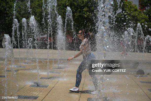 Cuban tourist cools off at a water fountain in the Monumento a la Revolucion square during a heat wave that hits Mexico City on April 16, 2024....