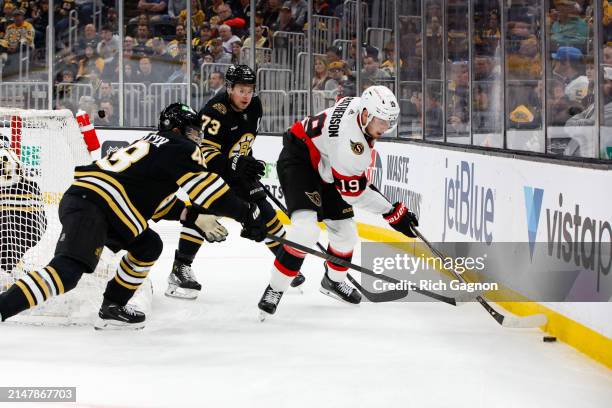 Matt Grzelcyk and Charlie McAvoy of the Boston Bruins check Drake Batherson of the Ottawa Senators during the second period at the TD Garden on April...