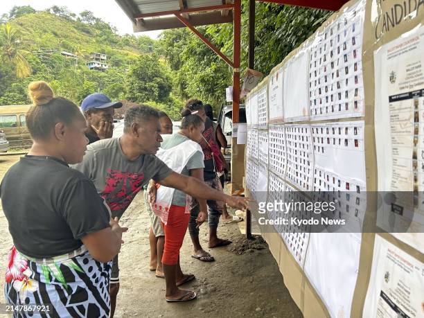 People look at a list of candidates in Honiara, the capital of the Solomon Islands, on April 17 the day of a general election.