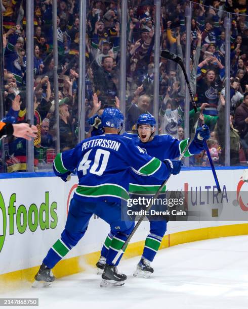 Nils Hoglander of the Vancouver Canucks is congratulated after scoring a goal against the Calgary Flames during the first period of the NHL game at...