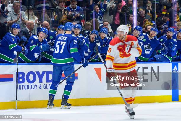 Tyler Myers of the Vancouver Canucks is congratulated at the bench after scoring a goal against the Calgary Flames during the first period of the NHL...