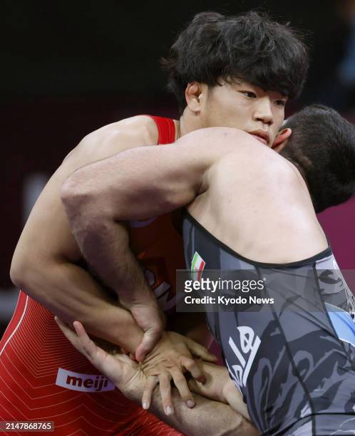 Taizo Yoshida of Japan grapples with Rasoul Sadegh Garmsiri of Iran in the men's Greco-Roman 82-kilogram final at the Asian wrestling championships...
