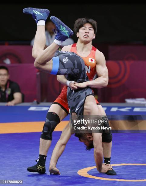 Shingo Harada of Japan competes against Mohammadreza Mahmoud Rostami of Iran in the men's Greco-Roman 72-kilogram final at the Asian wrestling...