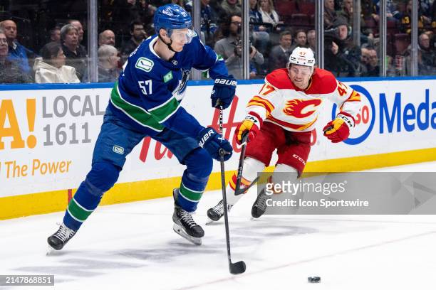 Vancouver Canucks defenseman Tyler Myers and Calgary Flames center Connor Zary vie for the puck during an NHL game between the Calgary Flames and the...