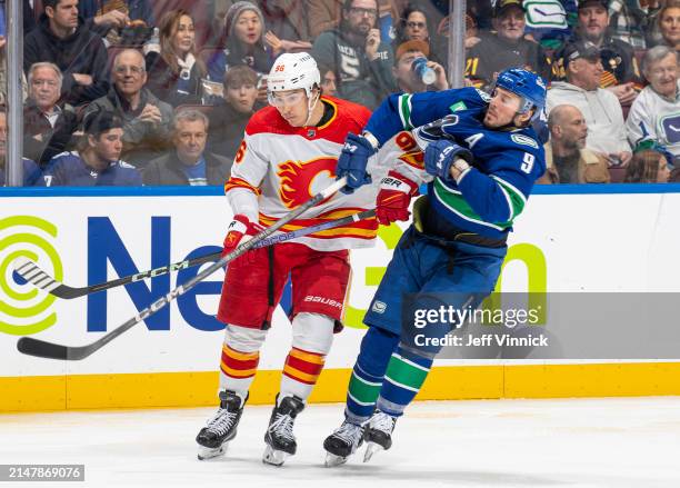 Miller of the Vancouver Canucks and Andrei Kuzmenko of the Calgary Flames battle for the puck during the second period of their NHL game at Rogers...
