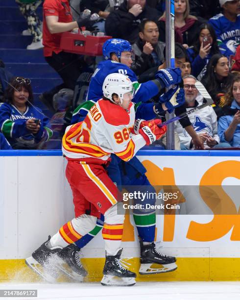 Nikita Zadorov of the Vancouver Canucks is checked by Andrei Kuzmenko of the Calgary Flames during the second period of the NHL game at Rogers Arena...
