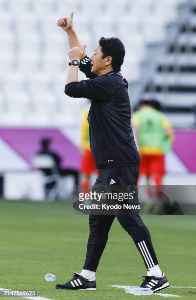 Japan manager Go Oiwa gives instructions to his players during an under-23 Asian Cup men's football group-stage match against China in Doha on April...