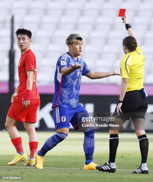 Japan's Ryuya Nishio is shown a red card during the first half of an under-23 Asian Cup men's football group-stage match against China in Doha on...
