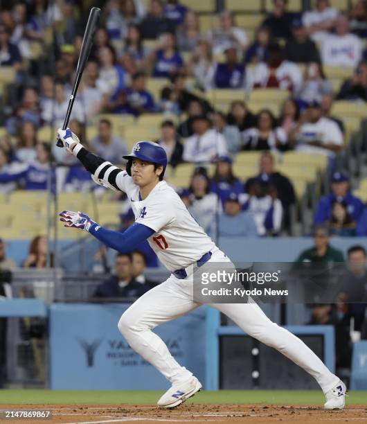 Shohei Ohtani of the Los Angeles Dodgers hits a single in the first inning of a baseball game against the Washington Nationals at Dodger Stadium in...
