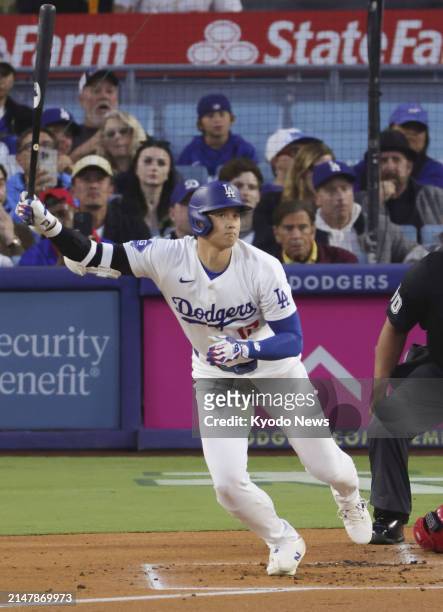 Shohei Ohtani of the Los Angeles Dodgers hits a single in the first inning of a baseball game against the Washington Nationals at Dodger Stadium in...