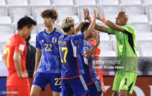 Japan players celebrate after defeating China in an under-23 Asian Cup men's football group-stage match in Doha on April 16, 2024.