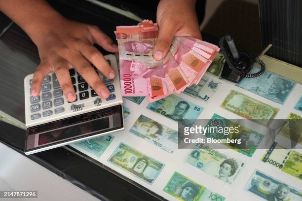 Worker counts Indonesian rupiah banknotes at a currency exchange office in Tanggerang, Banten, Indonesia, on Wednesday, April 17 2024. The rupiah's...