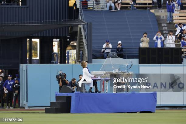 Japanese musician and songwriter Yoshiki performs in centerfield prior to the game between the Los Angeles Dodgers and the Washington Nationals at...