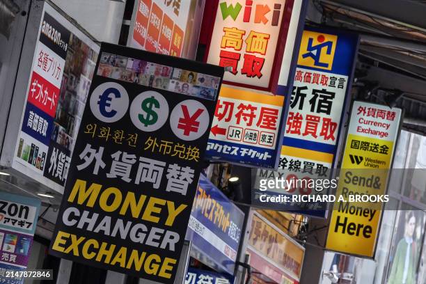 Signage for currency exchange shops is pictured along a street in central Tokyo on April 17 as the yen continues its downward spiral against the US...