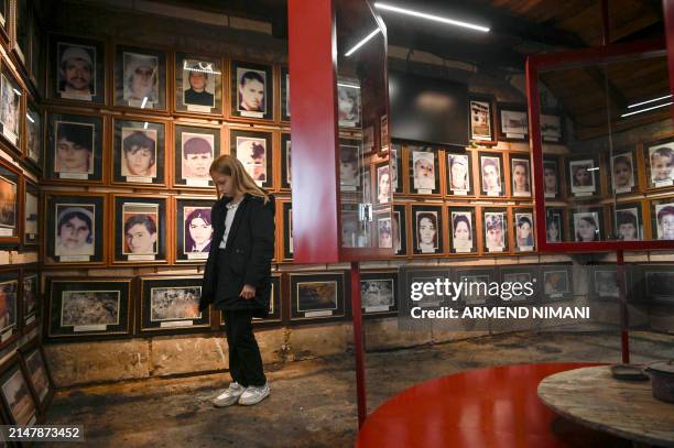 Young girl looks at the pictures of 53 people killed by Serbian security forces on April 17, 1999 in the village of Poklek near the town of Drena, to...