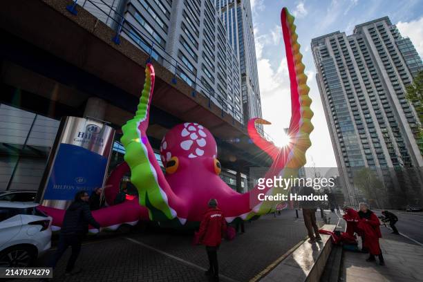 In this handout provided by Greenpeace, Greenpeace activists protest outside the Hilton, Canary Wharf on the opening morning of the annual Deep Sea...