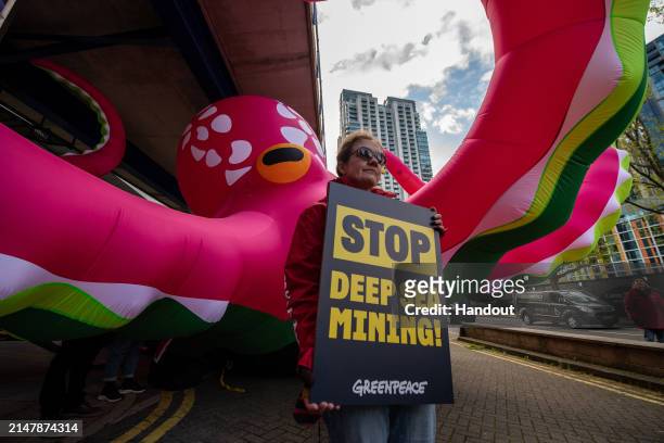 In this handout provided by Greenpeace, Greenpeace activists protest outside the Hilton, Canary Wharf on the opening morning of the annual Deep Sea...