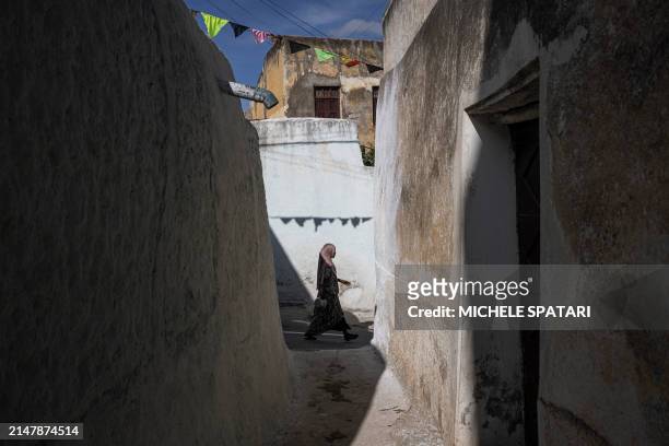Woman walks in a street inside Harar walled city on April 17, 2024. Founded in the 10th century, Harar - also called Jugol - is reputed to be one of...