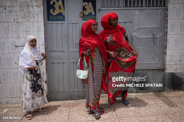 Young women dressed in traditional attires walk down a street inside Harar walled city on April 17, 2024. Founded in the 10th century, Harar - also...