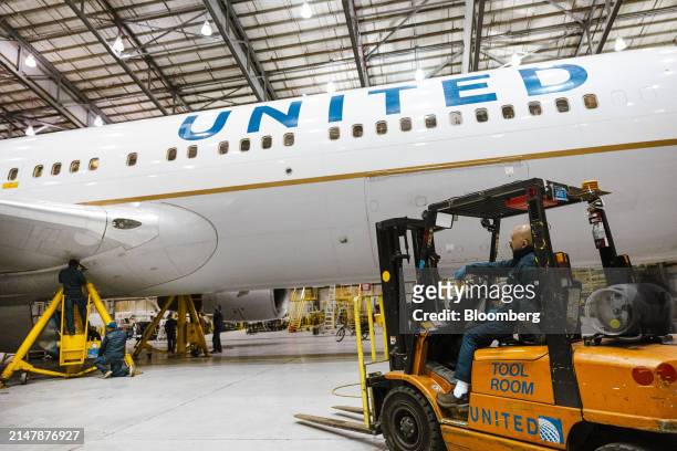 Worker drives a forklift near a Boeing 767-300 airplane in a United Airlines maintenance hangar at Newark Liberty International Airport in Newark,...