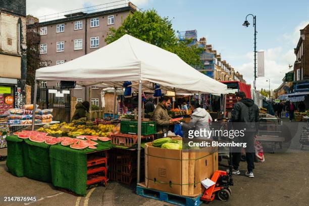 Shoppers pick fresh fruit from a grocery stall at East Street Market in London, UK, on Wednesday, April 17, 2024. UK inflation slowed less than...