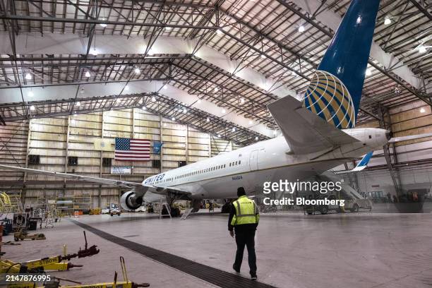 Worker walks towards a Boeing 767-300 airplane in a United Airlines maintenance hangar at Newark Liberty International Airport in Newark, New Jersey,...