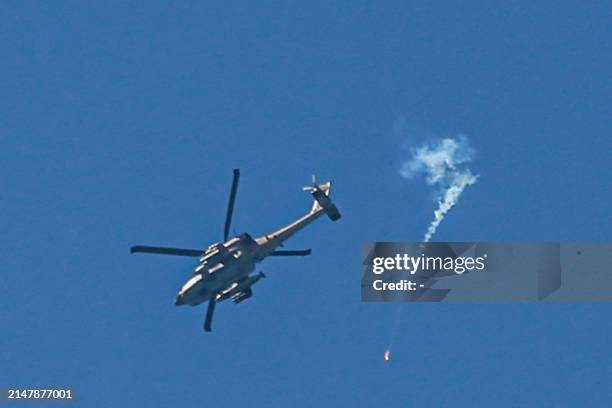 An Israeli Air Force attack helicopter fires a flare during a flyover above Nuseirat in the central Gaza Strip on April 17, 2024 amid the ongoing...