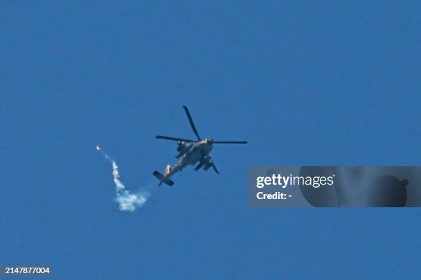 An Israeli Air Force attack helicopter fires a flare during a flyover above Nuseirat in the central Gaza Strip on April 17, 2024 amid the ongoing...