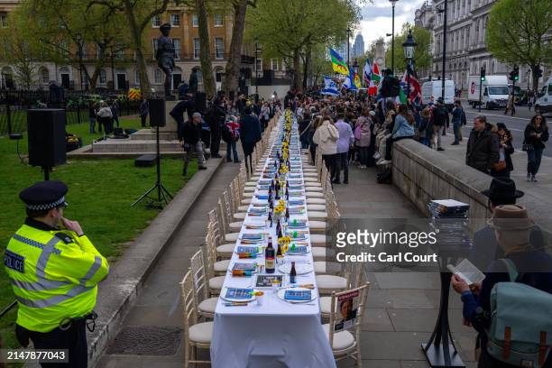 People prepare to gather around an empty seder table featuring 133 chairs representing the hostages taken by Hamas on October 7th, during a protest...