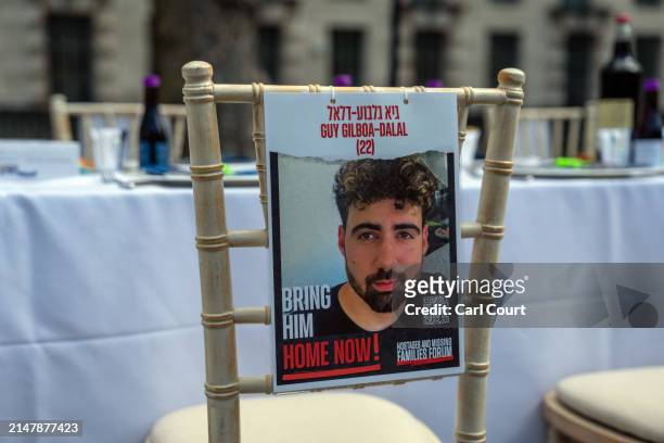 Missing poster is hung on a chair at an empty seder table featuring 133 chairs representing the hostages taken by Hamas on October 7th, during a...