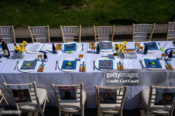Missing posters are hung on chairs at an empty seder table featuring 133 chairs representing the hostages taken by Hamas on October 7th, during a...