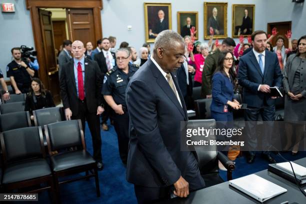 Protesters raise their hands as Lloyd Austin, US secretary of defense, center, arrives for a House Appropriations Subcommittee on Defense hearing in...