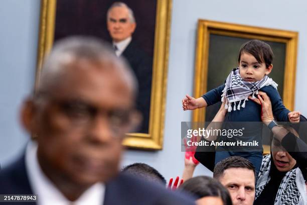 Protester from the group Code Pink holds up a child and disrupts U.S. Secretary of Defense Lloyd Austin as he speaks at a House Appropriations...