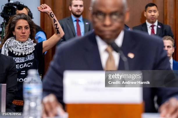 Protester from the group Code Pink holds up her arm with the word "Gaza" written on it as U.S. Secretary of Defense Lloyd Austin speaks at a House...
